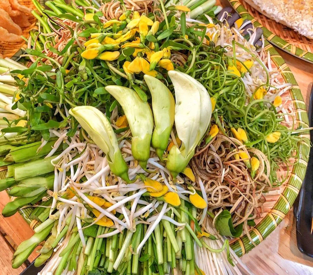 Mâm rau vườn: bông súng, bông điên điển, dưa chuối ăn kèm món kho – nướng